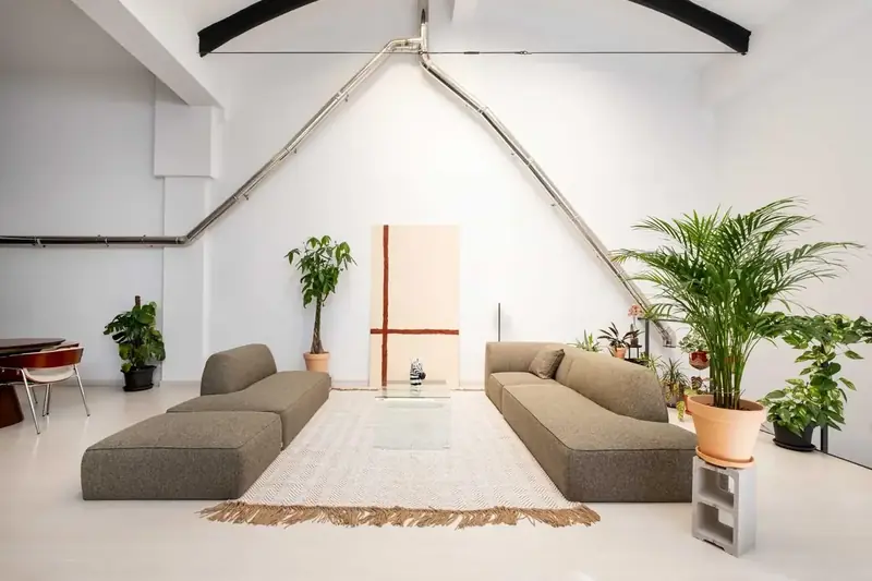 Salón diáfano bajo la cubierta original en un local convertido en vivienda en Zaragoza