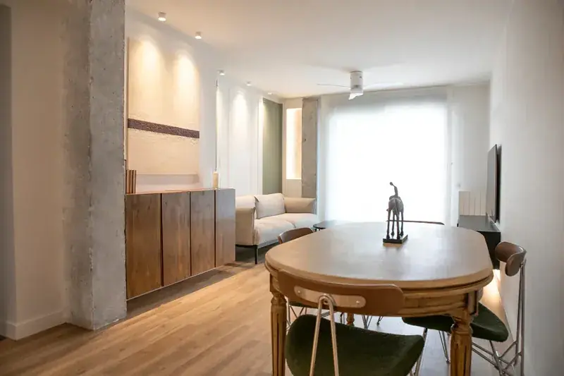Salón comedor reformado en Zaragoza con el pilar original visto y aparador de madera a medida